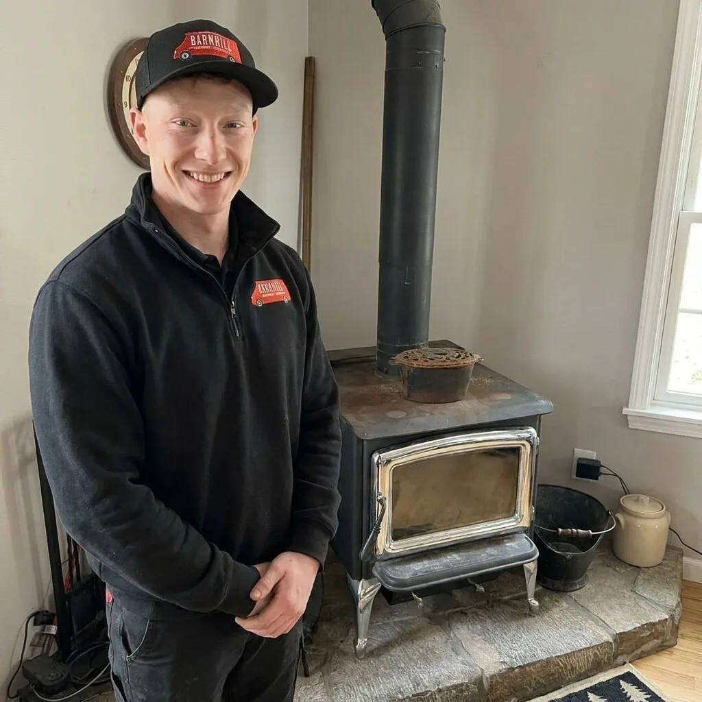 Barnhill technician beside a wood stove during a chimney sweep and inspection in Lexington, KY
