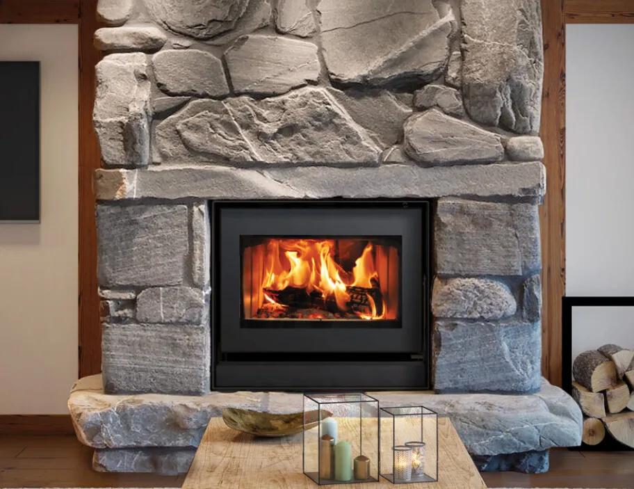 A stone fireplace with a new insert installed by Barnhill Chimney